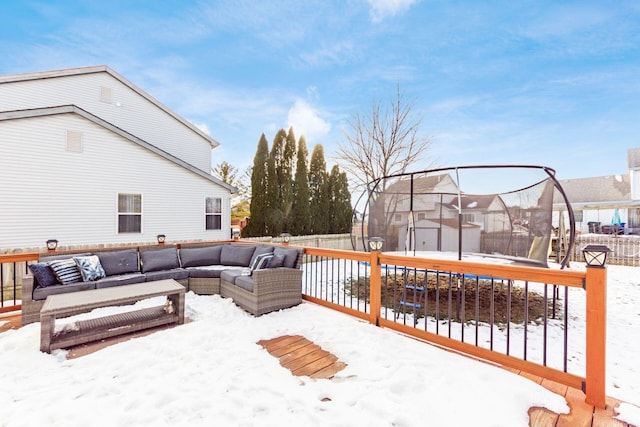 snow covered deck featuring outdoor lounge area and a trampoline