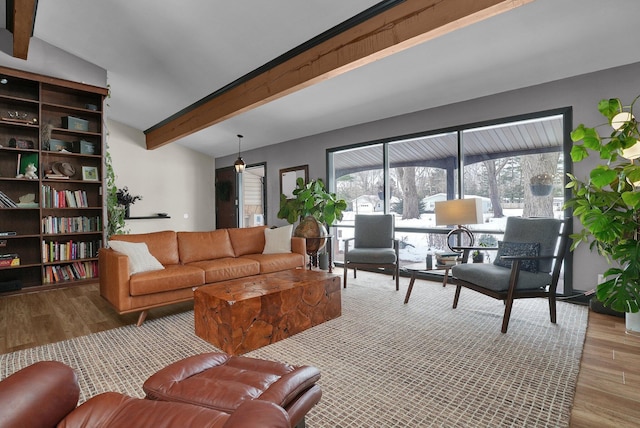 living area featuring beam ceiling and wood finished floors