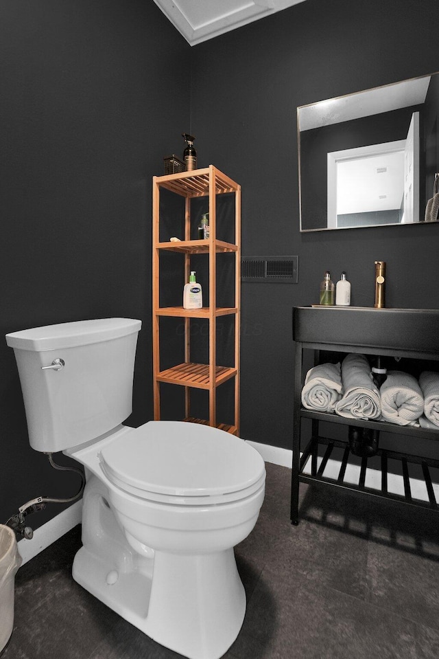 bathroom featuring baseboards and toilet