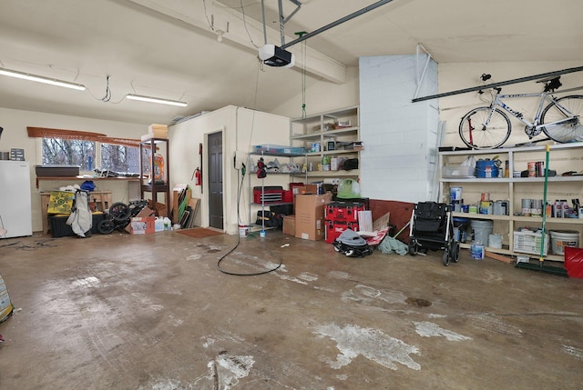 garage featuring a garage door opener and white refrigerator