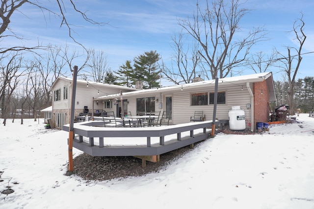 snow covered house with a wooden deck