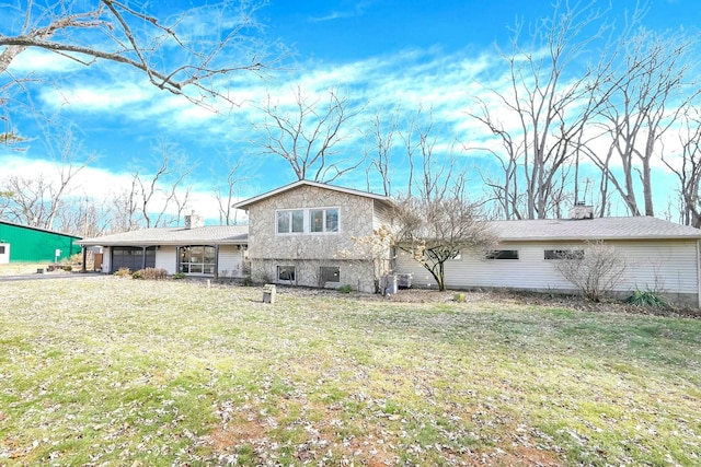 view of front facade with a garage, a chimney, and a front lawn