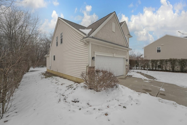 snow covered property featuring a garage