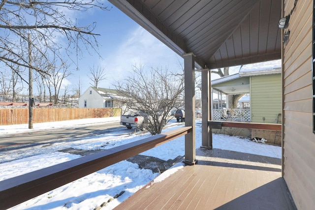 snow covered deck featuring covered porch