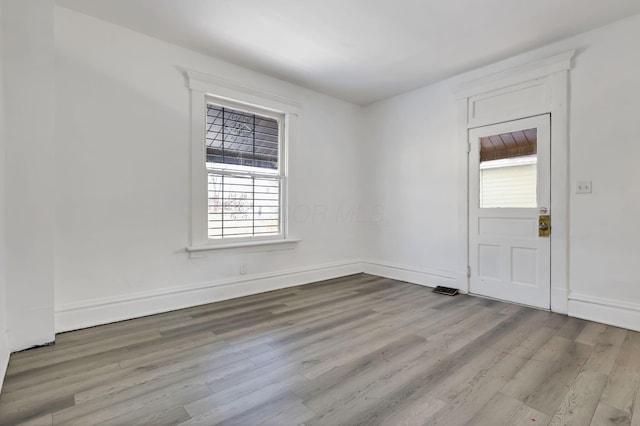 spare room with plenty of natural light and light wood-type flooring