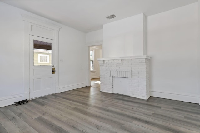 unfurnished living room featuring hardwood / wood-style flooring and a fireplace