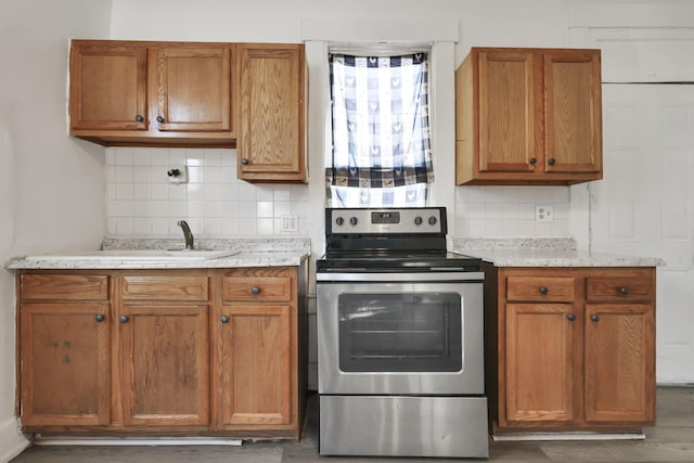 kitchen featuring tasteful backsplash, light stone counters, and electric range