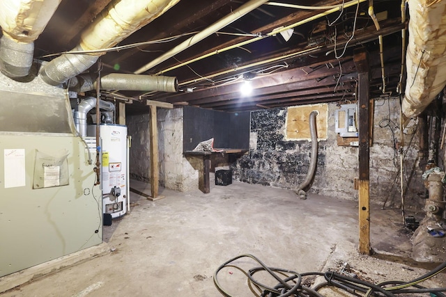 basement featuring heating unit, electric panel, and water heater