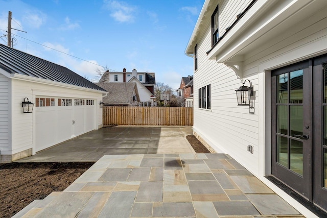 view of patio with an outbuilding and a garage