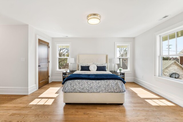 bedroom featuring multiple windows and light hardwood / wood-style floors