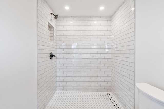 bathroom featuring toilet and tiled shower