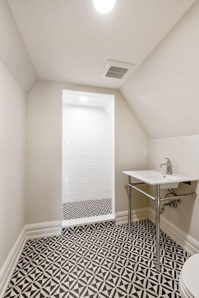 bathroom featuring walk in shower, vaulted ceiling, and toilet