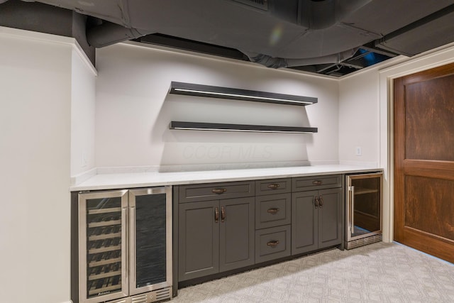 bar with dark brown cabinets and beverage cooler