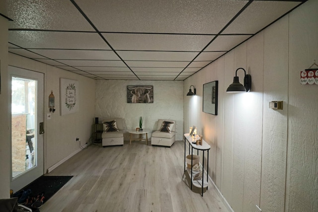 sitting room with a paneled ceiling and light hardwood / wood-style flooring