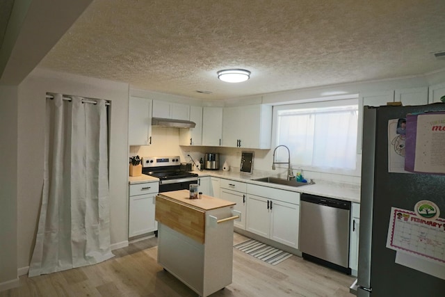 kitchen featuring light wood-type flooring, stainless steel appliances, sink, and white cabinets