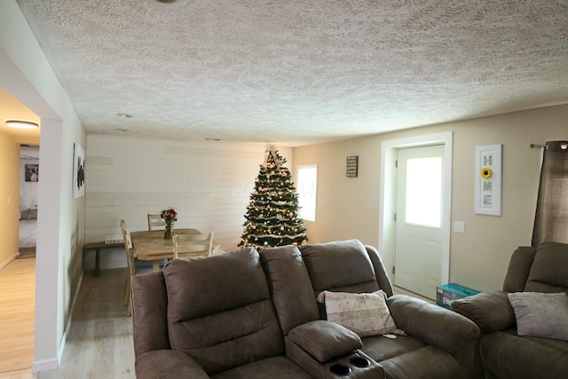 living room featuring a textured ceiling and light wood-type flooring