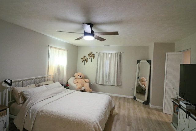 bedroom featuring a textured ceiling, ceiling fan, and light hardwood / wood-style floors