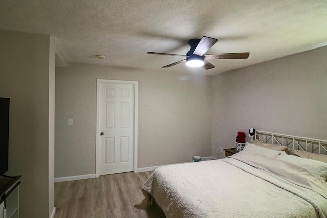 bedroom featuring a textured ceiling, light hardwood / wood-style floors, and ceiling fan