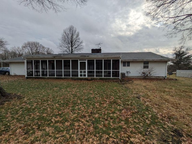 back of property with a yard and a sunroom