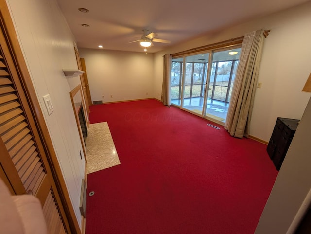 living room featuring ceiling fan, a fireplace, and carpet floors