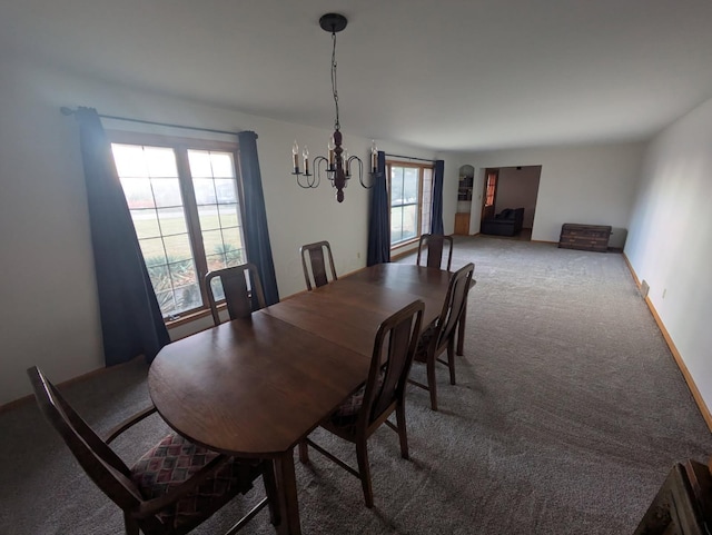 carpeted dining space featuring an inviting chandelier