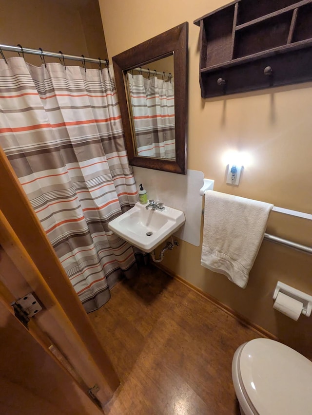 bathroom featuring sink, wood-type flooring, and toilet