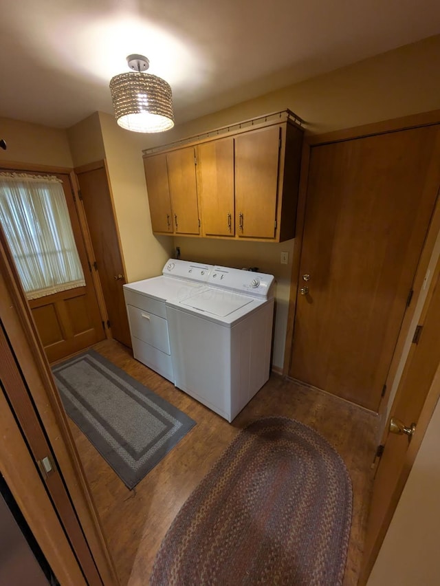 clothes washing area with cabinets, light wood-type flooring, and washer and clothes dryer