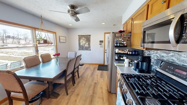 dining area featuring ceiling fan, a textured ceiling, and light hardwood / wood-style floors