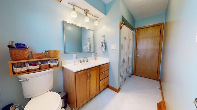 bathroom featuring vanity, a textured ceiling, and toilet