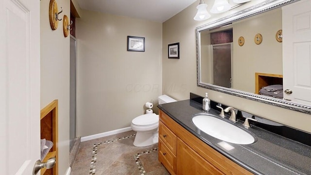 bathroom with tile patterned flooring, vanity, a shower with door, and toilet