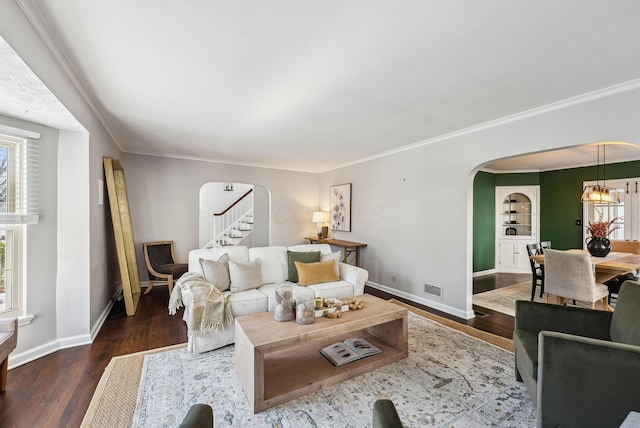 living room featuring dark wood-type flooring and ornamental molding