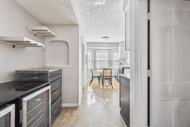 kitchen featuring wine cooler and a textured ceiling