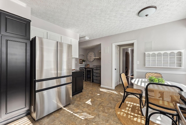 kitchen with stainless steel fridge, beverage cooler, and a textured ceiling