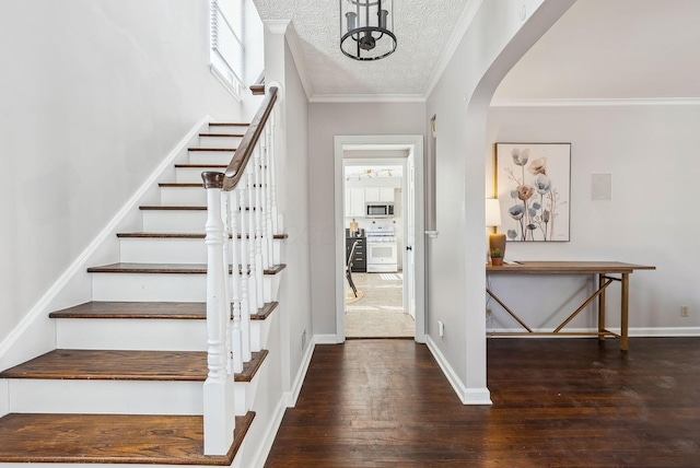 entrance foyer featuring crown molding, dark hardwood / wood-style floors, and a textured ceiling