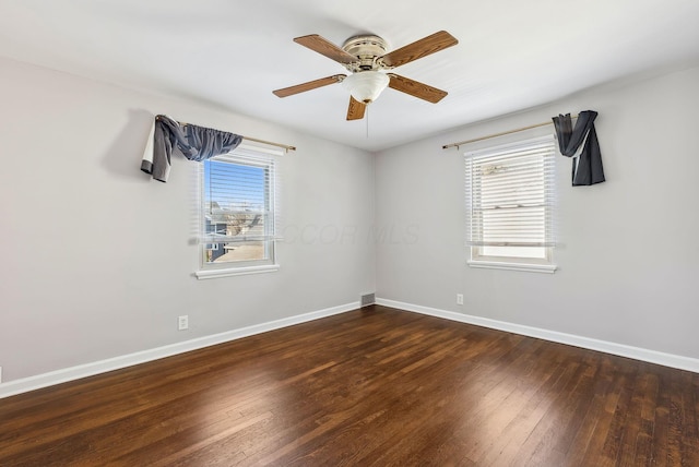 spare room with plenty of natural light, dark hardwood / wood-style floors, and ceiling fan