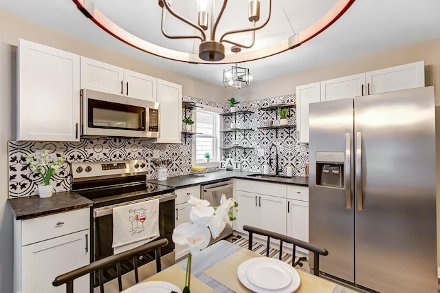 kitchen with white cabinetry, sink, pendant lighting, and stainless steel appliances