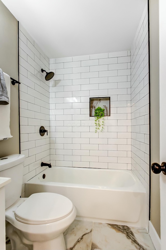 bathroom featuring tiled shower / bath and toilet