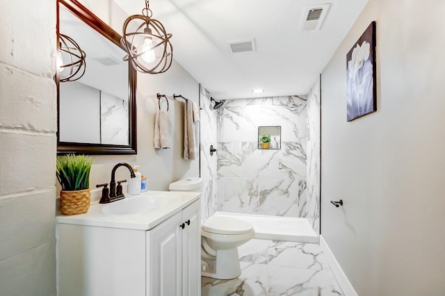 bathroom featuring vanity, tiled shower, and toilet