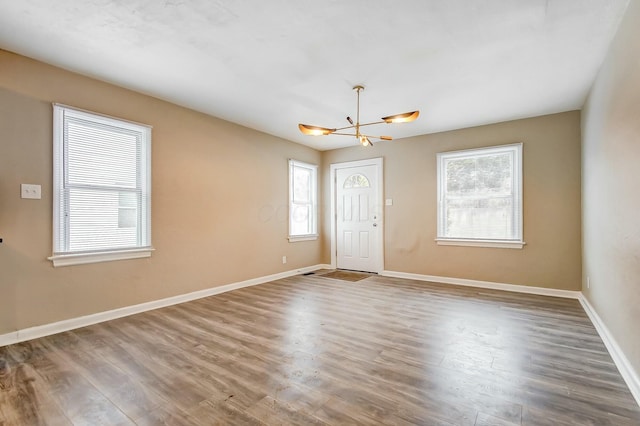 spare room with wood-type flooring and a chandelier