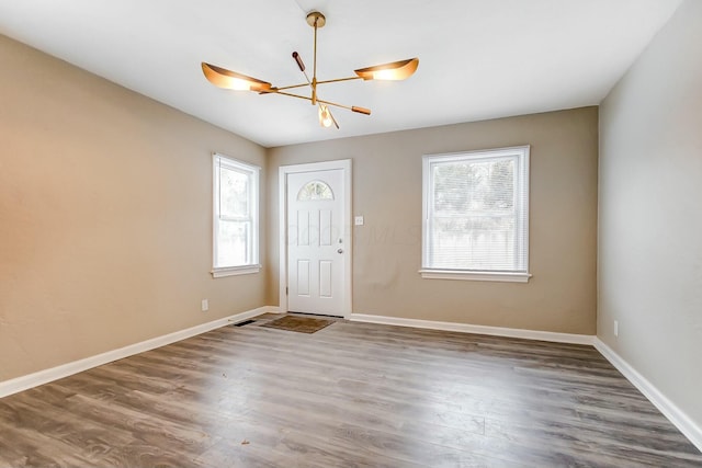 entryway with dark hardwood / wood-style flooring, a notable chandelier, and a healthy amount of sunlight