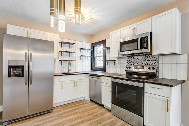 kitchen with white cabinetry, appliances with stainless steel finishes, sink, and decorative backsplash