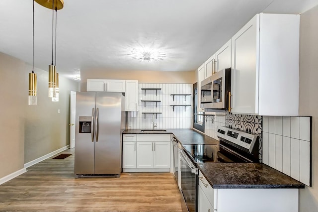 kitchen featuring pendant lighting, sink, backsplash, stainless steel appliances, and white cabinets