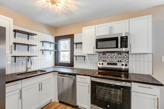 kitchen featuring white cabinetry, appliances with stainless steel finishes, sink, and backsplash