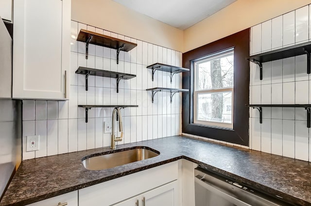 kitchen with white cabinetry, stainless steel dishwasher, sink, and decorative backsplash