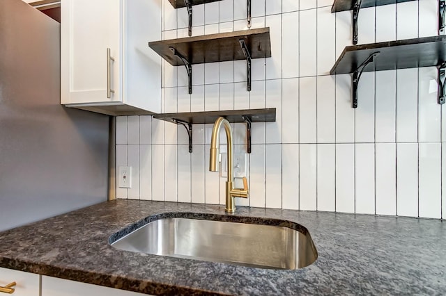 kitchen with white cabinetry, sink, and tasteful backsplash