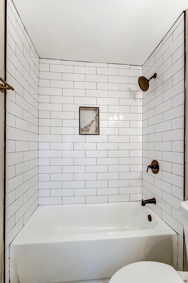 bathroom with tiled shower / bath and toilet