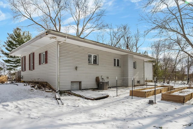 view of snow covered exterior with central AC