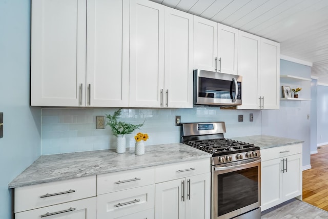 kitchen with light hardwood / wood-style flooring, stainless steel appliances, and white cabinets