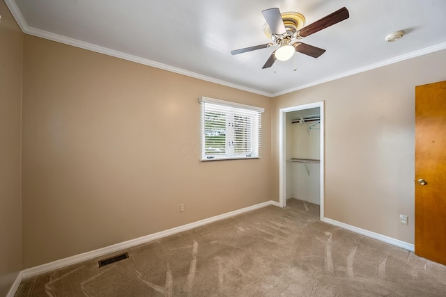 unfurnished bedroom with ornamental molding, light colored carpet, ceiling fan, and a closet