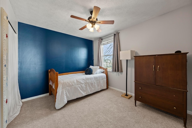 carpeted bedroom featuring ceiling fan and a textured ceiling